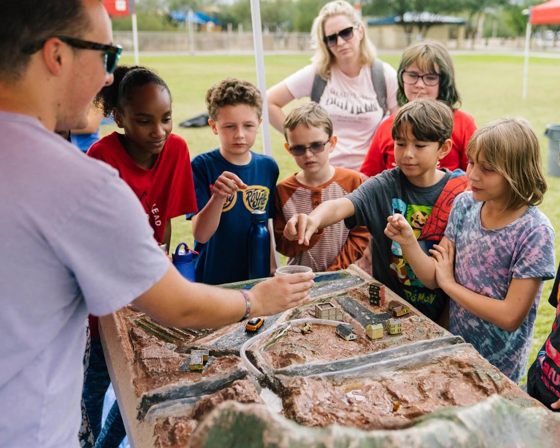 Students playing with a 3-d model of a watershed