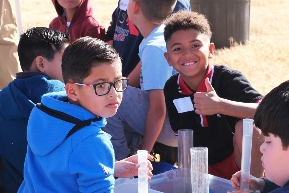 Student with a thumb up at a water festival activity
